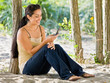 Woman text messaging on cell phone at beach