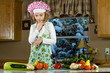 Child chef making a decision about vegetables