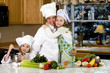 Happy family cooking dinner in chef uniform