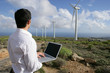 Homme avec ordinateur portable sur un site d'éoliennes
