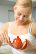 Young happy smiling woman with pomegranate at kitchen Young happy smiling woman with pomegranate at kitchen