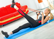 Young happy woman doing fitness exercises at home