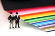 Photo: Gay men standing by rainbow paper. Gay marriage concept. Gay men standing by rainbow paper. Gay marriage concept.