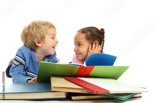 Photo: Kids laying down and reading a book Kids laying down and reading a book