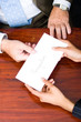 a business woman handing in a letter of resignation to her boss