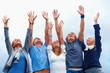 Photo: Young men and women raising hands against sky Young men and women raising hands against sky