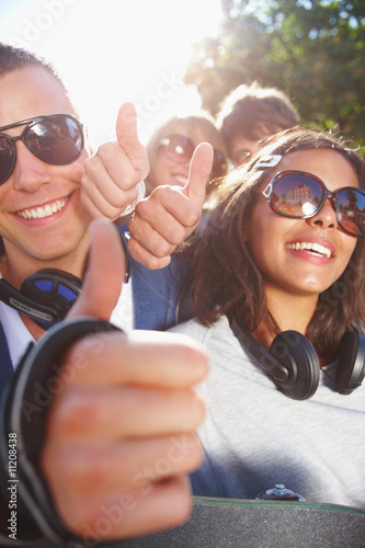 Foto: Happy young friends showing thumb's up sign Happy young friends showing thumb's up sign