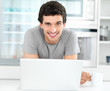 Portrait of a smiling young smart man with a laptop