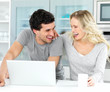 Young couple having fun while using a laptop