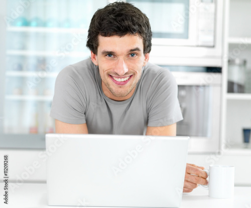 Photo: Portrait of a smiling young smart man with a laptop Portrait of a smiling young smart man with a laptop
