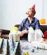 Young boy wearing a party hat with blower in mouth at home