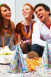 Closeup of party hats on the table with people in background
