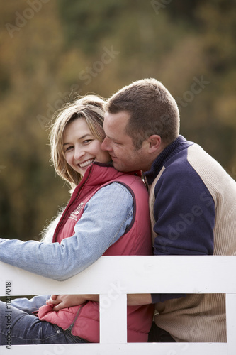 Photo: couple sitting on a bench at a lake in autumn couple sitting on a bench at a lake in autumn