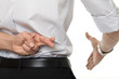 gekreuzte Finger bei Handschlag