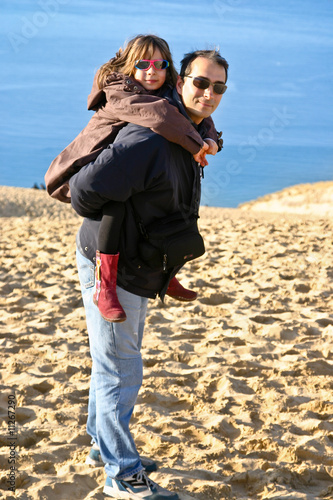 Photo: ravie d'être sur le dos de son père ravie d'être sur le dos de son père
