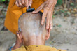 monk getting head shaved by fellow monk monk getting head shaved by fellow monk