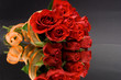 red roses with orange ribbon against the black background
