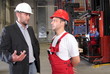 boss talking to worker in uniform in factory