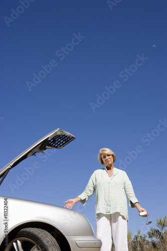 Photo: Woman standing near broken car Woman standing near broken car