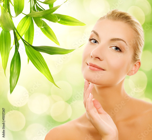 Beautiful young woman applying organic cosmetics to her skin