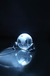 Glassy globe with headphones on dark background