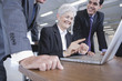 Businessmen and businesswoman working on laptop