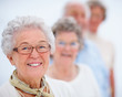 Foto: Smiling older woman standing in a line Smiling older woman standing in a line