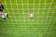 Soccer player standing near ball and goal net