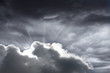 Sun shining behind dark clouds