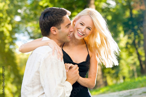 Photo: Young happy smiling couple walking outdoors together Young happy smiling couple walking outdoors together