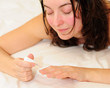 Young woman using nail polish
