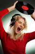 Singing beautiful woman with headphones and vinyl record