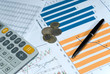 Financial reports with coins, pen and calculator