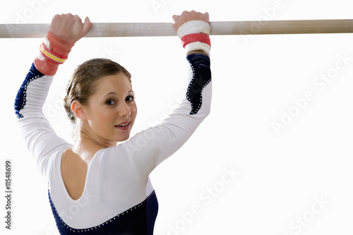 Photo: Female gymnast with hands on bar, smiling, portrait Female gymnast with hands on bar, smiling, portrait