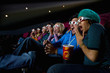 Audience in cinema wearing 3D glasses, making faces, low angle view