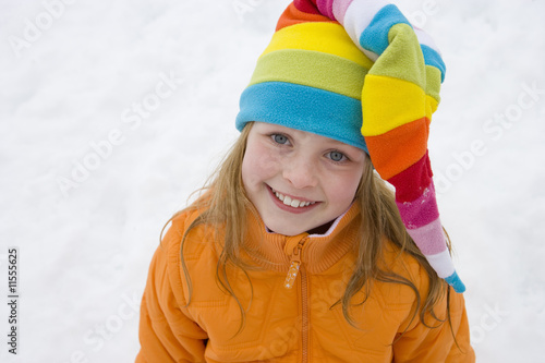 Photo: Portrait of young girl in multi-colored winter hat Portrait of young girl in multi-colored winter hat