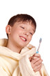A boy brushing his teeth after bath