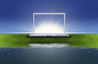 blank laptop computer on the green grass