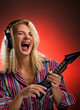 Beautiful young woman with headphones playing small electro guit
