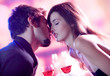 Young kissing couple celebrating with red wine together Young kissing couple celebrating with red wine together