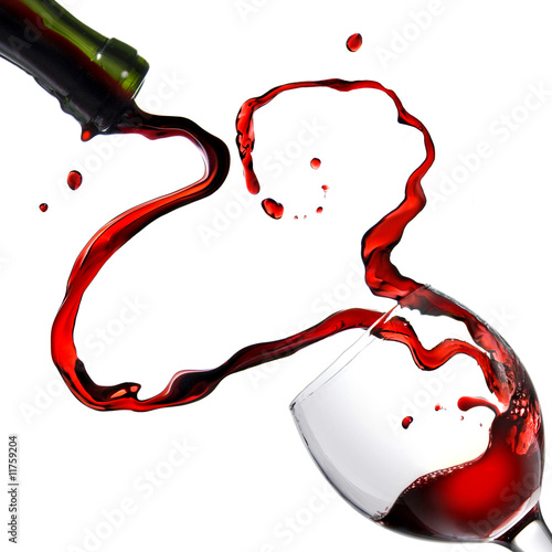 Heart from pouring red wine in goblet isolated on white