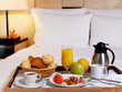 Tray with breakfast on a bed in a hotel room. Tray with breakfast on a bed in a hotel room.