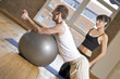 Photo: girl with a fitball and trainer in the gym girl with a fitball and trainer in the gym