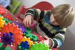 young child learning with some colourful cogs