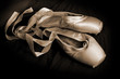 Worn ballet pointe shoes on a dark background. Worn ballet pointe shoes on a dark background.