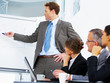 Confident business man demonstrating report to colleagues