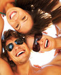 Group of happy young teenagers in circle at beach