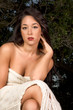 Sensual woman wrapped in scarf outdoors in garden