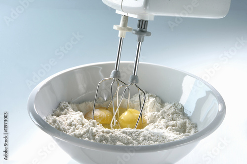 Photo: mixing flour and eggs with an electric hand mixer mixing flour and eggs with an electric hand mixer