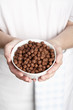 hands holding a bowl of chocolate flavoured puffed rice